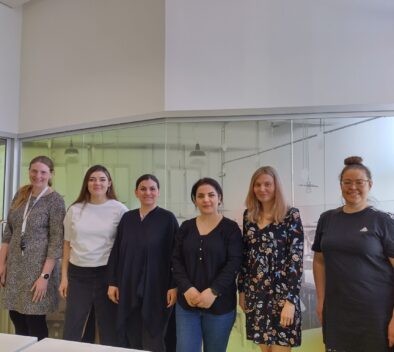 Kuvassa kuusi naista seisoo rivissä ja hymyilee.