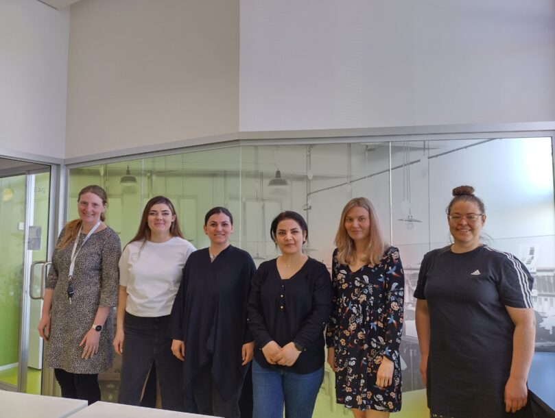 Kuvassa kuusi naista seisoo rivissä ja hymyilee.