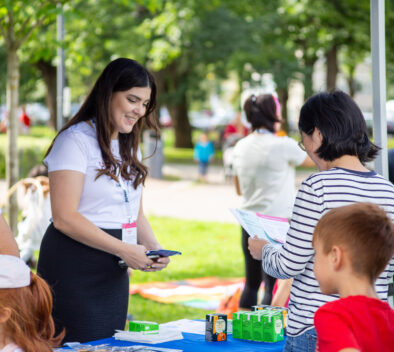 Kuvassa nainen jakaa esitteitä lapsiperheille.