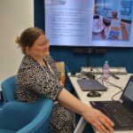 Anette Lindroos ja taustalla ruudulla esitys