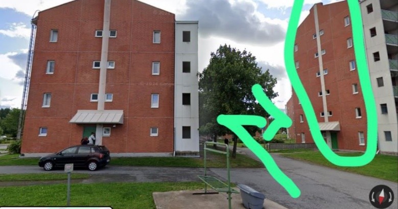 kahden kerrostalon välistä nuoli osoittaa sijaintiin